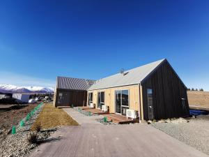 a home under construction with mountains in the background at Skyrim Lodge in Lake Tekapo