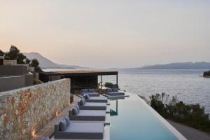 a row of chaise lounge chairs on a building overlooking the water at Azur Retreat in Meganisi