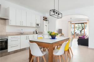 a kitchen with a table and yellow chairs at Cas Ferrerico in Costa des Pins