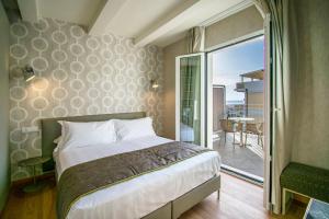 a bedroom with a bed and a balcony at Hotel Medusa in Lido di Camaiore