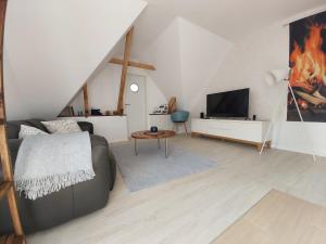 uma sala de estar com um sofá e uma televisão em Backstage Apartment Kiel-Holtenau em Kiel