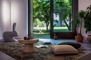 a living room with a table and a room with a window at Villa Rustico in Viboldone