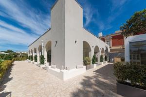 a white church with a row of plants in a courtyard at Insula Boutique Hotel in Procida
