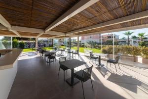 un patio al aire libre con mesas, sillas y ventanas en Insula Boutique Hotel en Procida