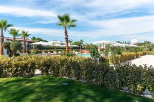 uma vista para um resort com uma piscina e palmeiras em Insula Boutique Hotel em Procida