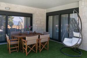 a dining room with a swing and a table and chairs at The Euphoria Club Luxury Villas in Pefkochori