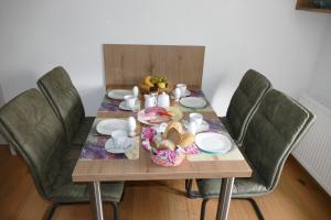 una mesa de madera con sillas y un plato de comida. en 4 Sterne Ferienwohnung Sommerberg inklusive Gästekarte en Rohrbach