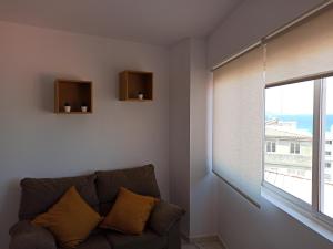 sala de estar con sofá y ventana en Apartamento marinero 2, en Malpica de Bergantiños