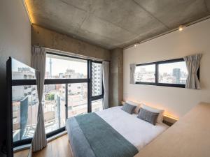 um quarto com uma cama e uma grande janela em dots. tokyo em Tóquio