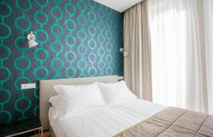 a bedroom with a bed and a blue wall at Hotel Medusa in Lido di Camaiore