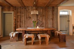 a dining room with a wooden table and stools at Ferienhaus Ickelhaus 1 in Bad Windsheim