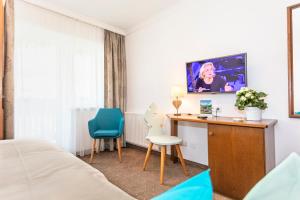 ein Hotelzimmer mit einem Schreibtisch und 2 Stühlen in der Unterkunft Pension Pinzgauer Hof in Maria Alm am Steinernen Meer