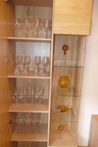 una mensola piena di bicchieri da vino in una stanza di 4 Sterne Ferienwohnung Sommerberg inklusive Gästekarte a Rohrbach