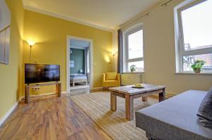 a living room with a couch and a tv at fewo1846 - Angelburg - komfortable Wohnung im Stadtzentrum in Flensburg