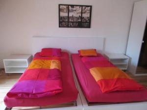 two beds in a room with colorful blankets at good bed Aarwangen in Aarwangen