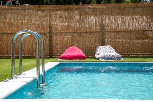- une piscine avec deux sacs de couchage à côté d'une clôture dans l'établissement The Euphoria Club Luxury Villas, à Pefkohori