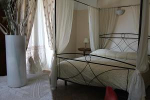 a bedroom with a bed and a vase at Hotel Porta Santa Maria in Busca