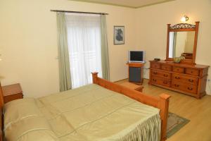 a bedroom with a bed and a dresser and a mirror at Hotel Venezia Imotski in Imotski