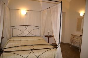 una camera con letto a baldacchino in metallo di Hotel Porta Santa Maria a Busca