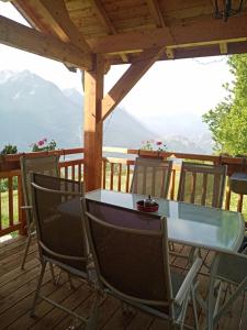 a table and chairs on a deck with a view at Chalet Mariabel in Puy-Saint-Pierre