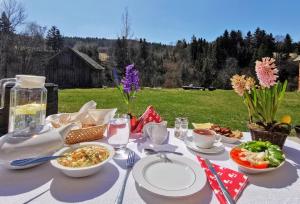 a table with plates and bowls of food on it at Wieś odNowa in Krynica Zdrój