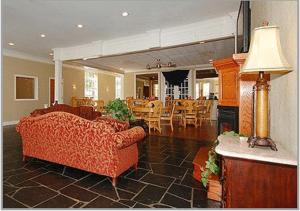 sala de estar con 2 sofás, mesa y sillas en Greenville Inn & Suites en Greenville