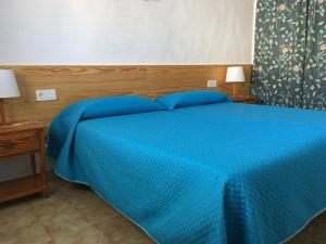 a bedroom with a blue bed with two blue pillows at Los Morros in Arrieta
