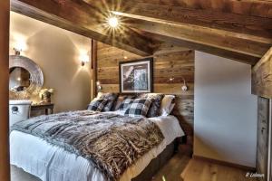 1 dormitorio con 1 cama y pared de madera en Astraea, en Peisey-Nancroix
