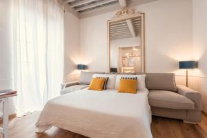 una camera con letto, divano e specchio di Palazzo Degli Archi a San Vincenzo