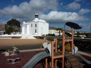 une aire de jeux en face d'un bâtiment blanc dans l'établissement Finca Lanzarosy, à Guatiza