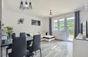a dining room and living room with a table and chairs at Apartament Glamour in Ustrzyki Dolne
