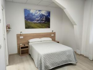 Un dormitorio con una cama y un cuadro en la pared. en Las Huertas, en La Penilla