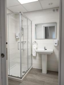 W łazience znajduje się szklana kabina prysznicowa i umywalka. w obiekcie Las Huertas w mieście La Penilla