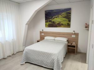1 dormitorio con 1 cama y una pintura en la pared en Las Huertas, en La Penilla