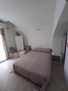 ein Schlafzimmer mit einem Bett in einem weißen Zimmer in der Unterkunft Bunari Studio Apartment in Rovinj