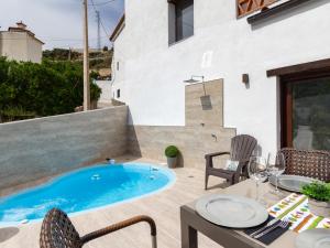 een patio met een zwembad en een tafel en stoelen bij Casa del rio in Saleres