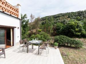 a patio with a table and chairs on a deck at Casa del rio in Saleres