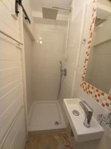 baño blanco con ducha y lavamanos en Bunari Studio Apartment, en Rovinj
