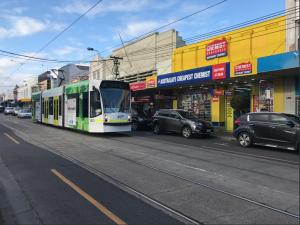 een bus rijdt door een straat met auto's bij Malvern Backpackers in Melbourne