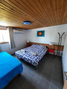 1 dormitorio con 2 camas y techo de madera en Sapir Apartment, en Sappir