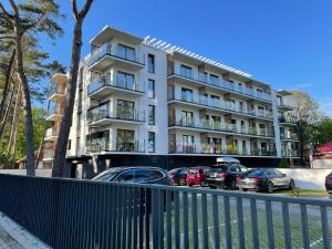 un edificio con coches estacionados frente a él en Apartament Dorado, en Mielno