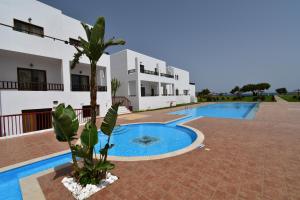 a villa with a swimming pool in front of a house at Geraniotis Hotel and Resort in Plataniás