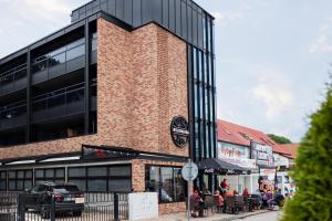 a brick building with people sitting outside of it at Blow up Baltic Trzęsacz in Trzęsacz