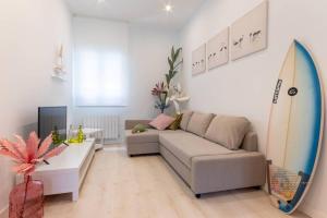 a living room with a couch and a surfboard at Old Town IV by Next Stop Bilbao in Bilbao