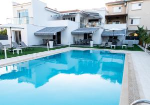 eine Villa mit einem Pool vor einem Haus in der Unterkunft Kypkeys Apartments in Oroklini
