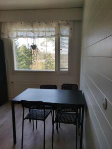 uma mesa e cadeiras num quarto com uma janela em Yyterin valkoinen huoneisto 14A talo B 21 em Pori
