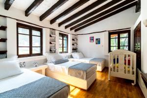 a bedroom with three beds and a crib at Forest Sani Villa in Sani Beach