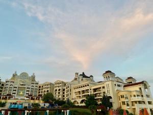 un grand immeuble avec un ciel nuageux en arrière-plan dans l'établissement Duni Marina Royal Palace Hotel - Ultra All Inclusive, à Sozopol