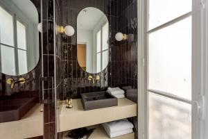 パリにあるHabitat Parisien - 2BR-2BA - Marais - Centre Pompidouの洗面台と鏡のあるバスルーム +33枚の写真