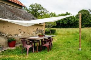 a table with chairs under a white canopy at Safaritent Les Pourettes in Feusines